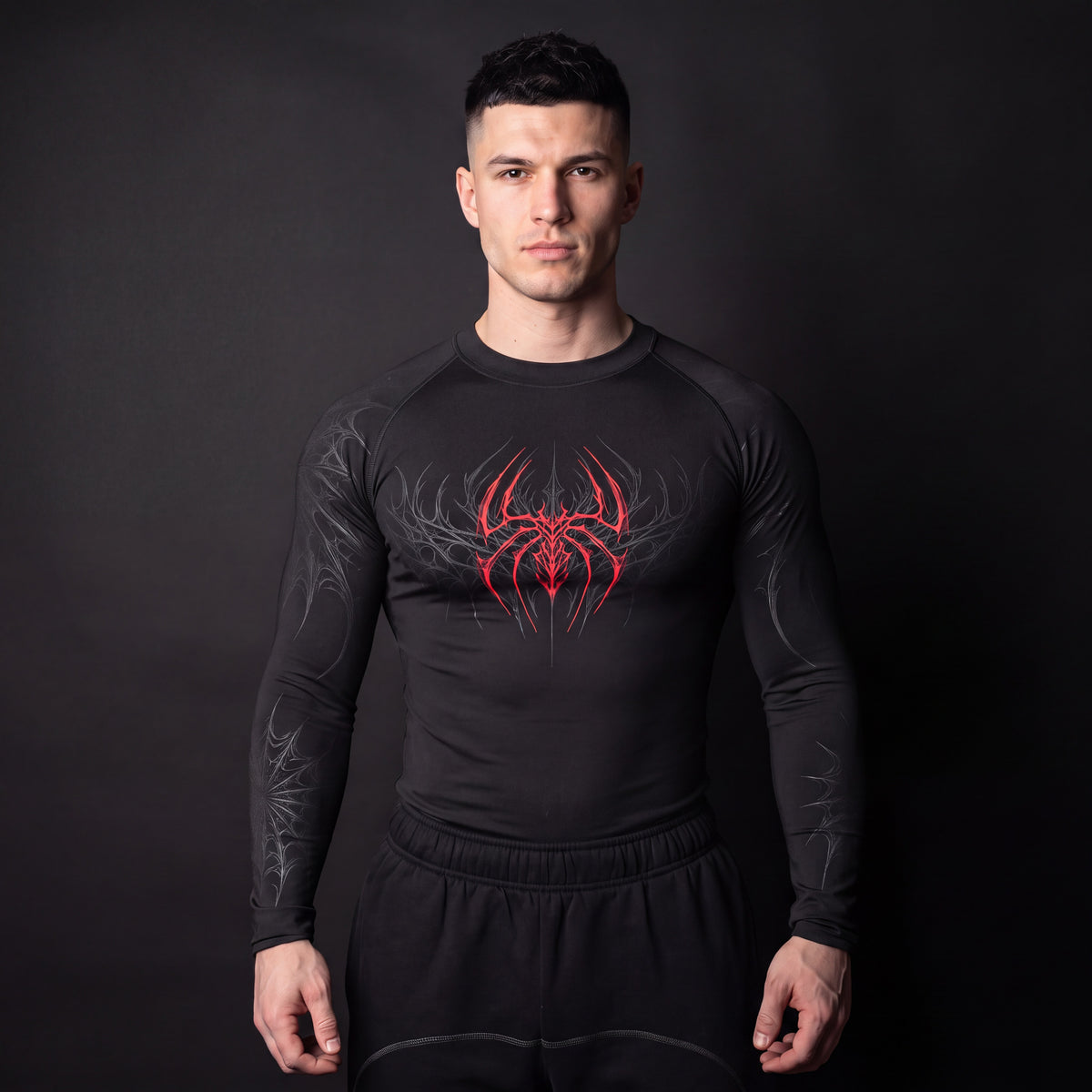 Symbiote Compression Shirt in Black & Red, front view on model, red spider chest graphic with grey gothic web sleeves
