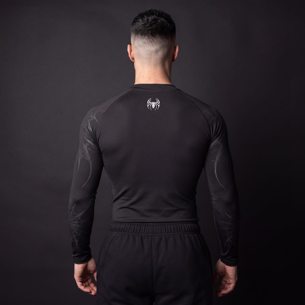 Symbiote Compression Shirt in Black & White, back view showing small white spider logo below the neckline