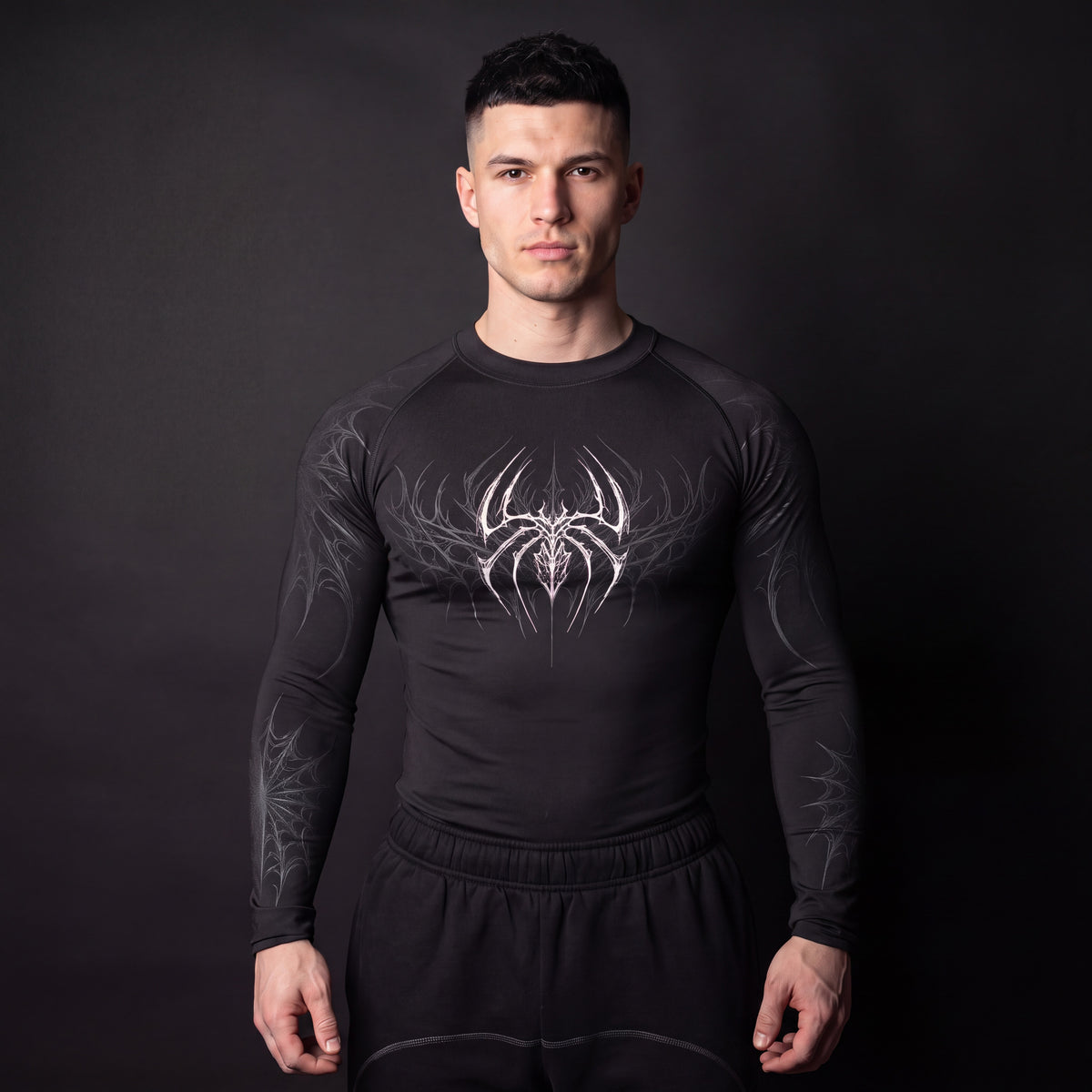 Symbiote Compression Shirt in Black & White, front view on model, white spider chest graphic with grey gothic web sleeves