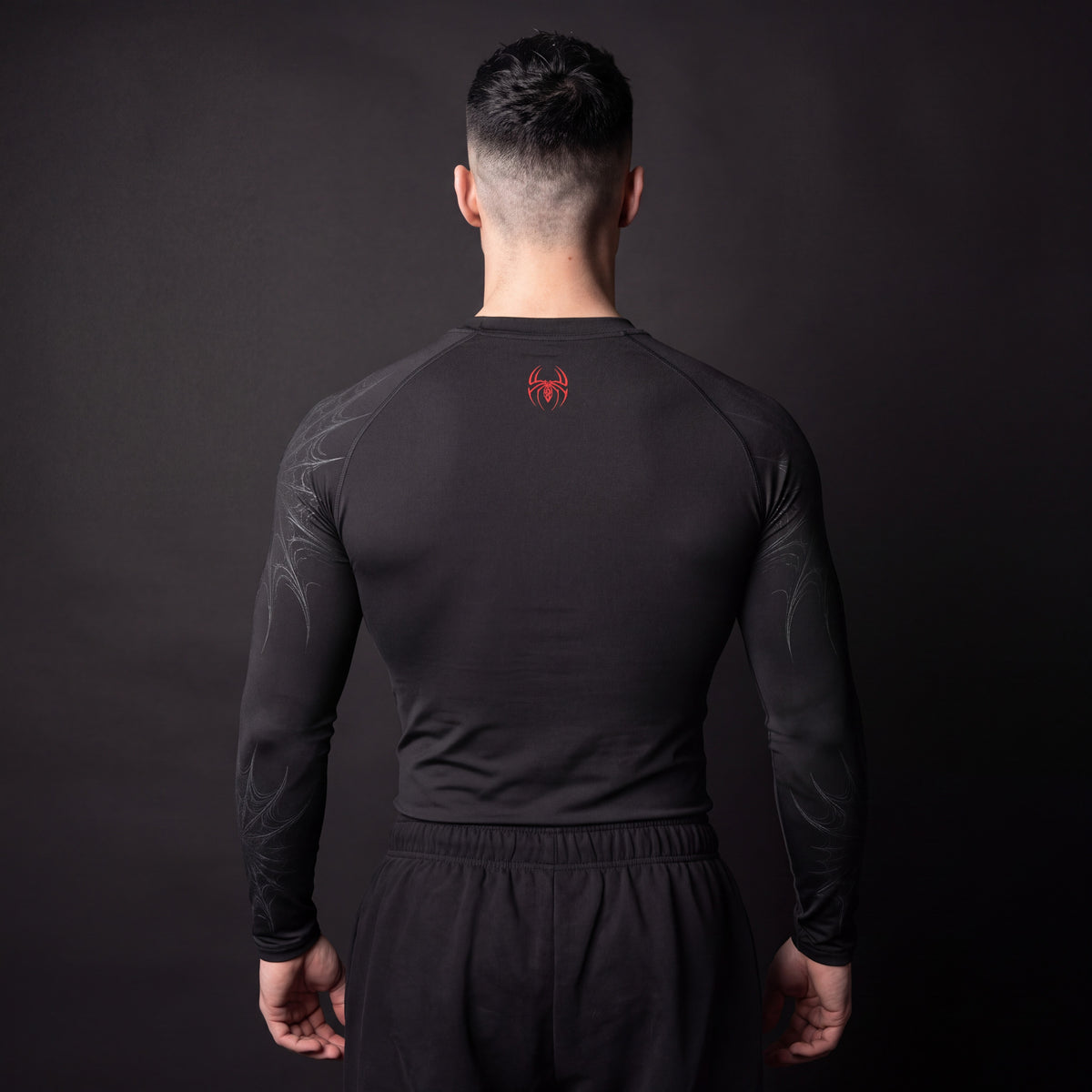 Symbiote Compression Shirt in Black & Red, back view showing small red spider logo below the neckline